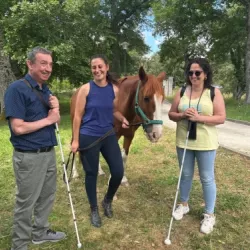 Grupo de personas sonrientes junto al caballo en un espacio natural