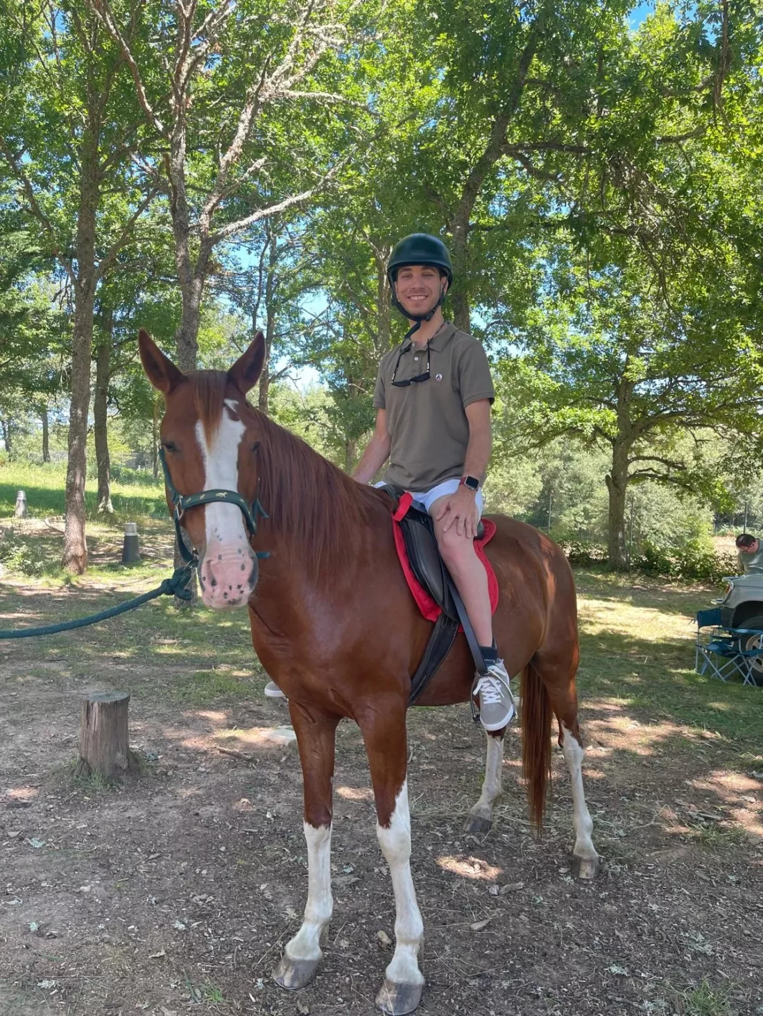 Persona montando un caballo con apoyo de dos guías.