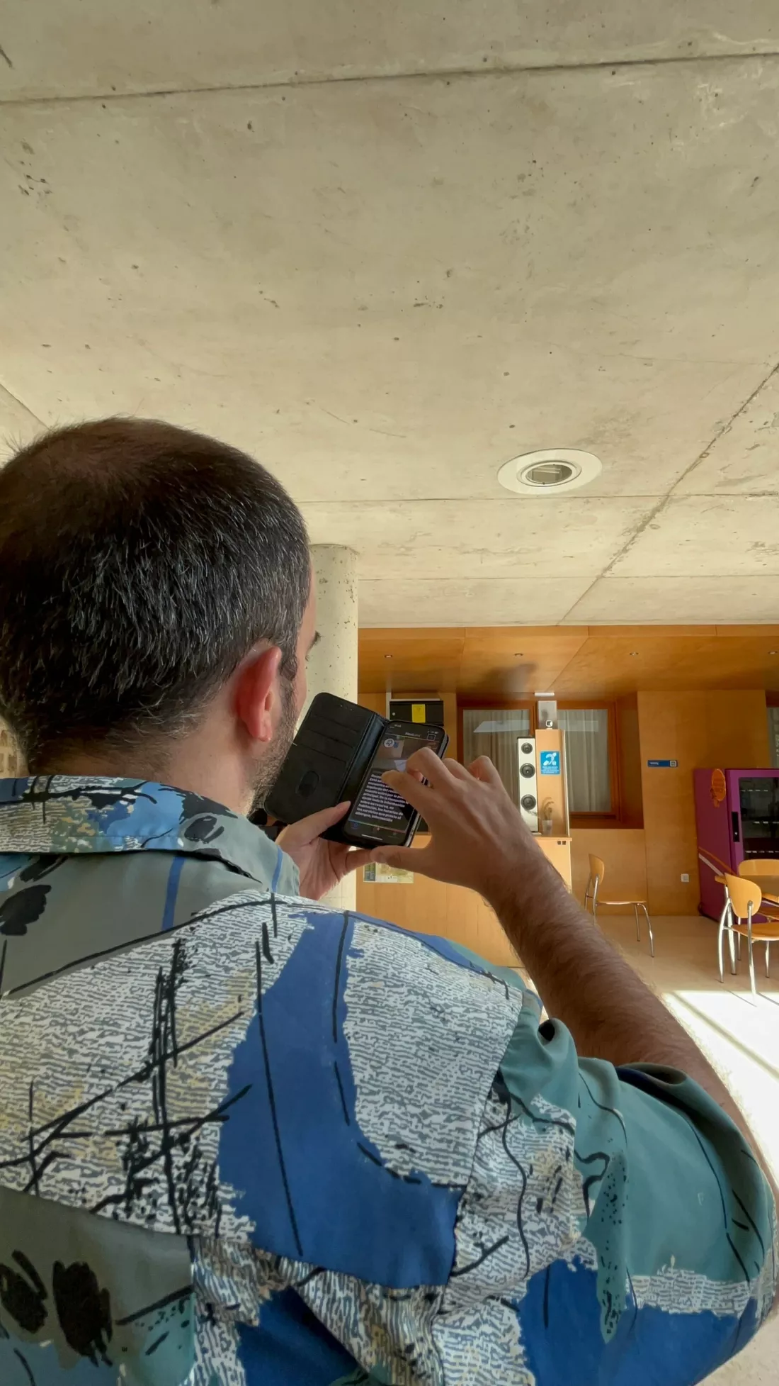 Hombre utiliza su móvil para leer información accesible en el interior del edificio.