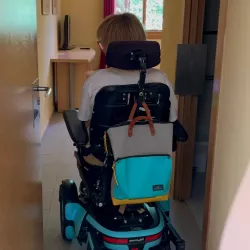Persona en silla de ruedas eléctrica accede a una habitación adaptada.