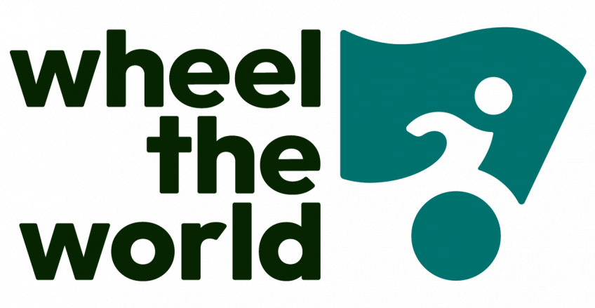 El logotipo de Wheel the World muestra el nombre de la plataforma en letras negras ("wheel the world") junto a un icono verde que representa a una persona en silla de ruedas, simbolizando el compromiso con el turismo accesible para todas las personas.