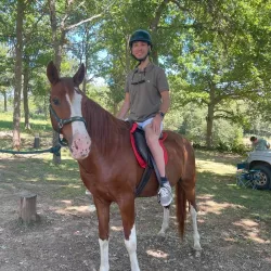 Persona montada en un caballo con ayuda de monitores