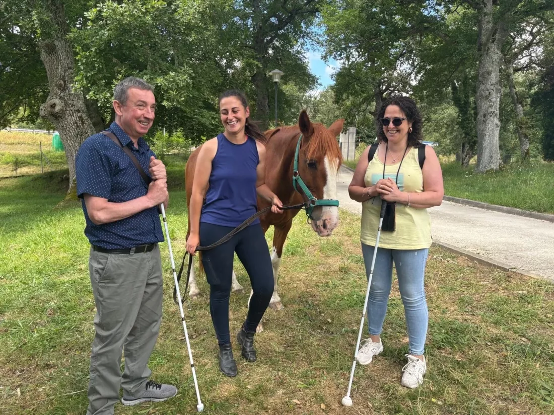 Grupo de personas sonrientes junto al caballo en un espacio natural