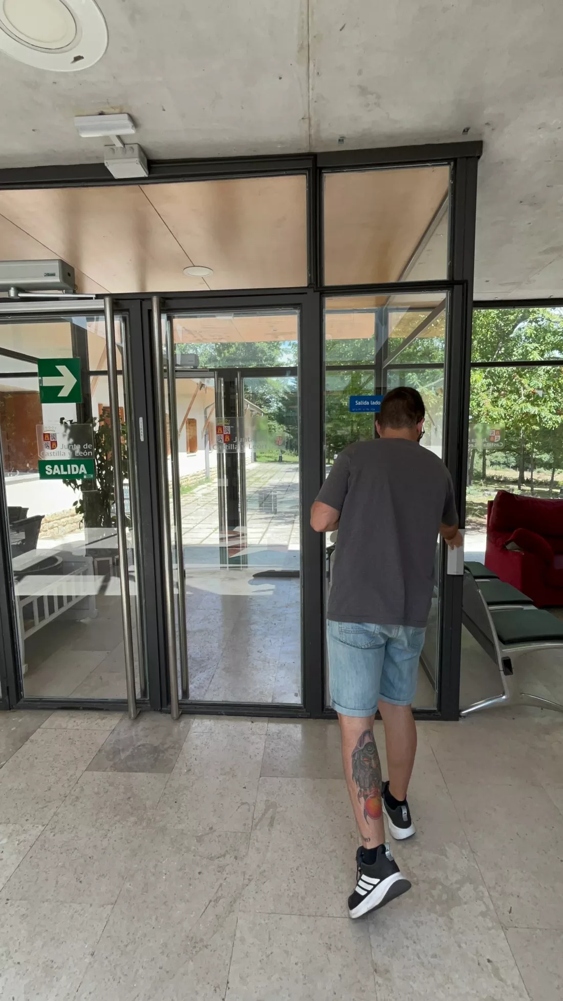Hombre se dirige hacia la salida de un edificio accesible.