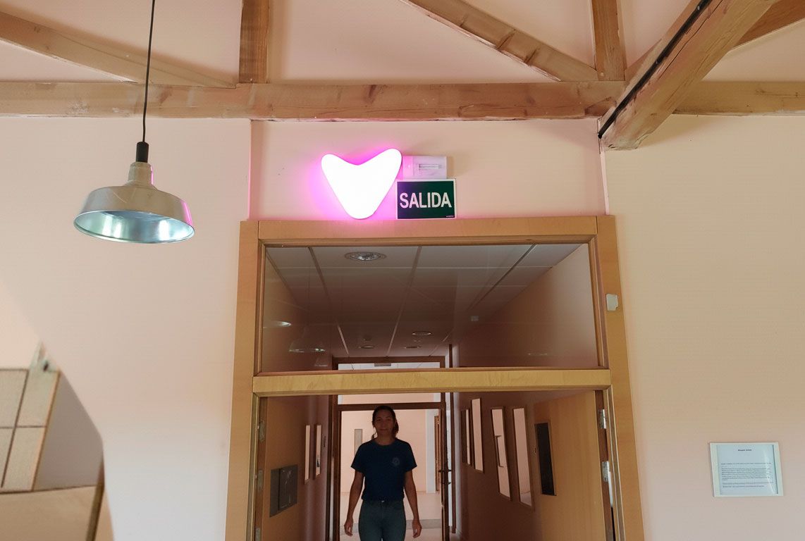 Una mujer joven cruza el umbral de una puerta de madera